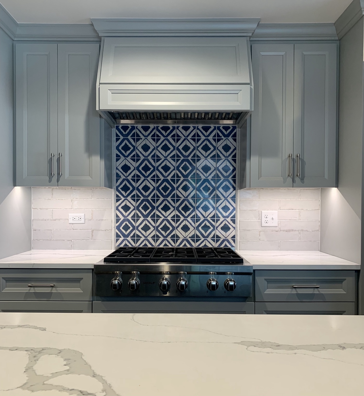 Custom kitchen range wall with detailed cabinetry and tile in Naperville renovation