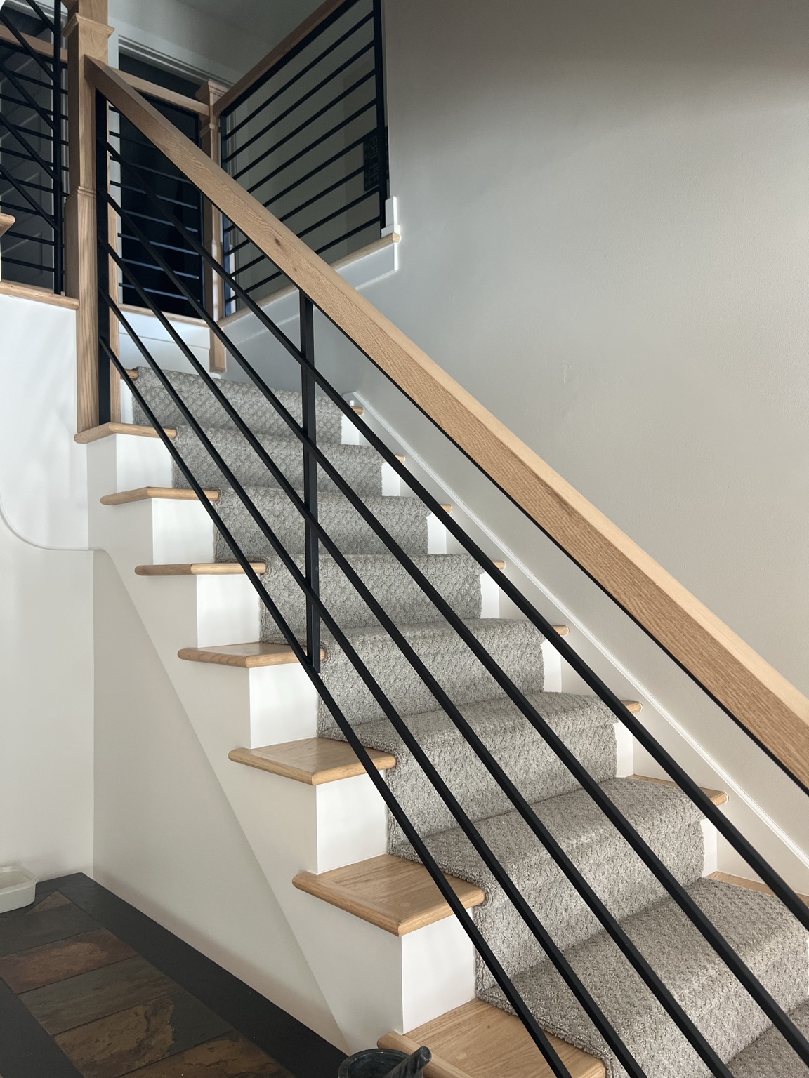 Custom stair renovation with wood rail and black metal balusters